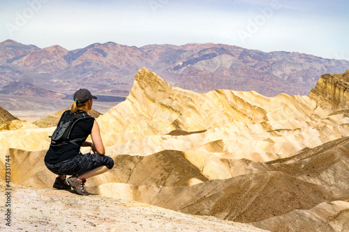 Young woman taking in the view of the arid Badlands on top of Zabriskie Point in Death Valley National Park - California, USA 