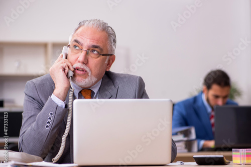 Two male employees working in the office © Elnur