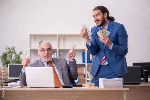 Old male boss and young male employee in remuneration concept