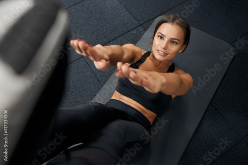 Cute woman working with abs in gym.
