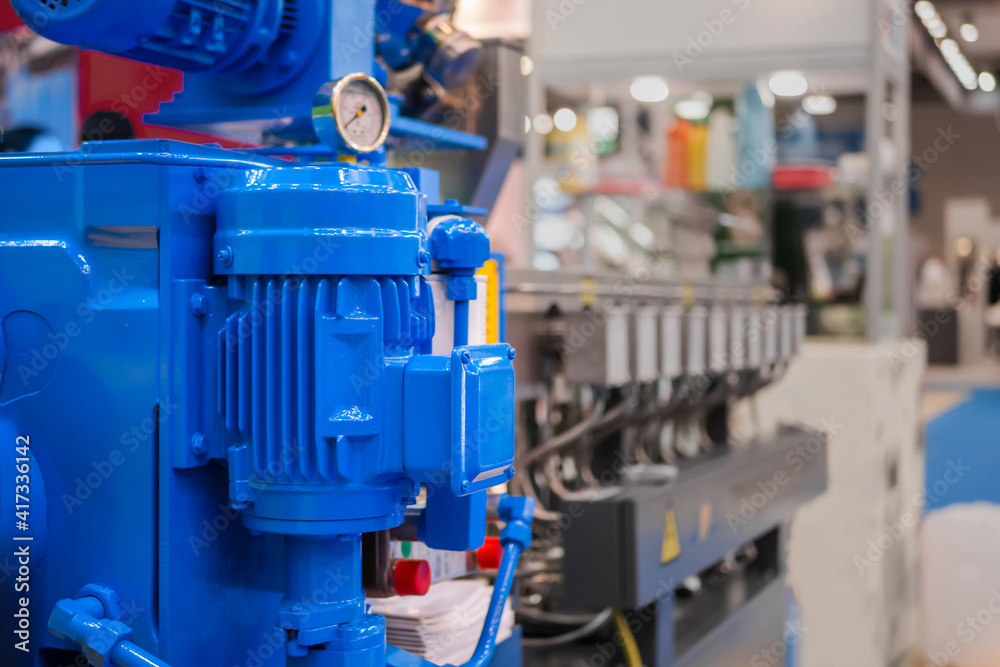Part of automatic injection molding machine at plastic exhibition, trade show. Manufacturing, production, technology concept Part of automatic injection molding machine at plastic exhibition, trade show. Manufacturing, production, technology concept