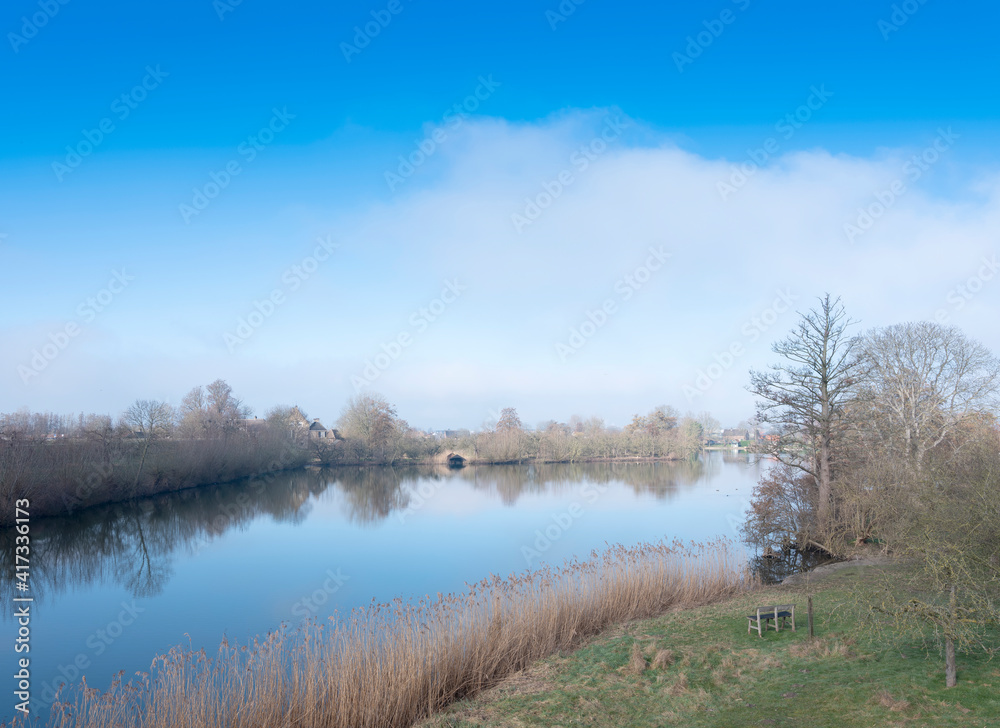 late winter landscape with water in the centre of holland under blue sky late winter landscape with water in the centre of holland under blue sky