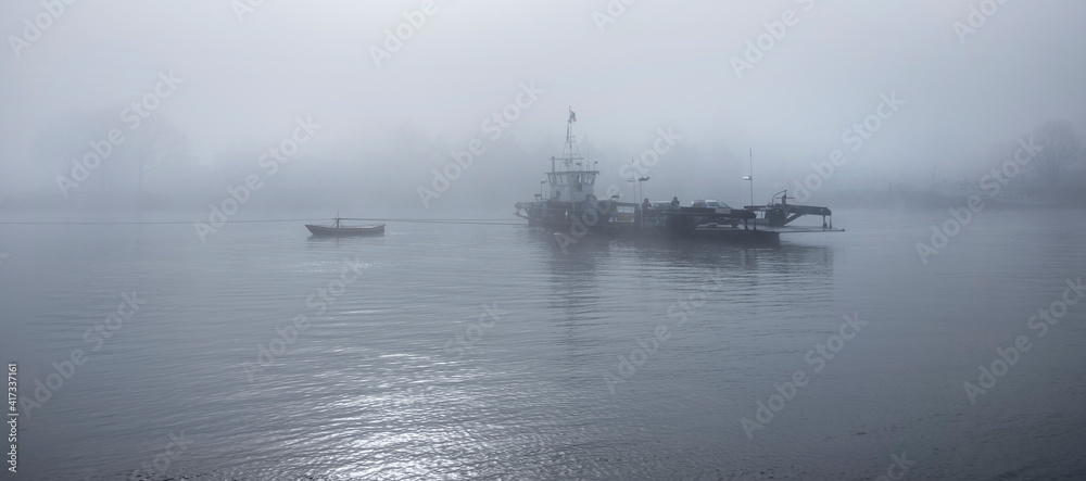 Fototapeta premium ferry in the mist on river lek near culemborg and utrecht