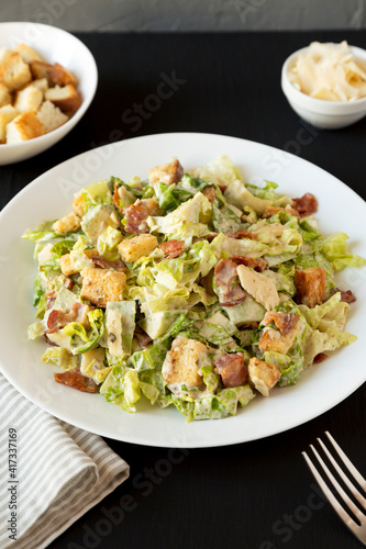 Homemade Bacon Avocado Caesar Salad with Cheese and Croutons, side view.