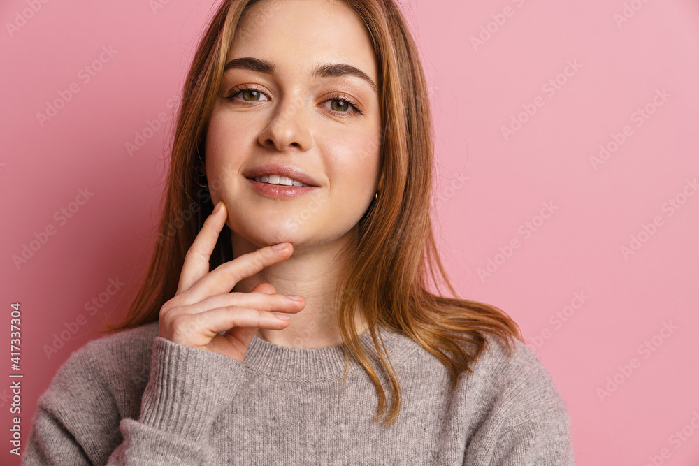 Fototapeta premium Portrait of a lovely attractive young girl isolated over pink