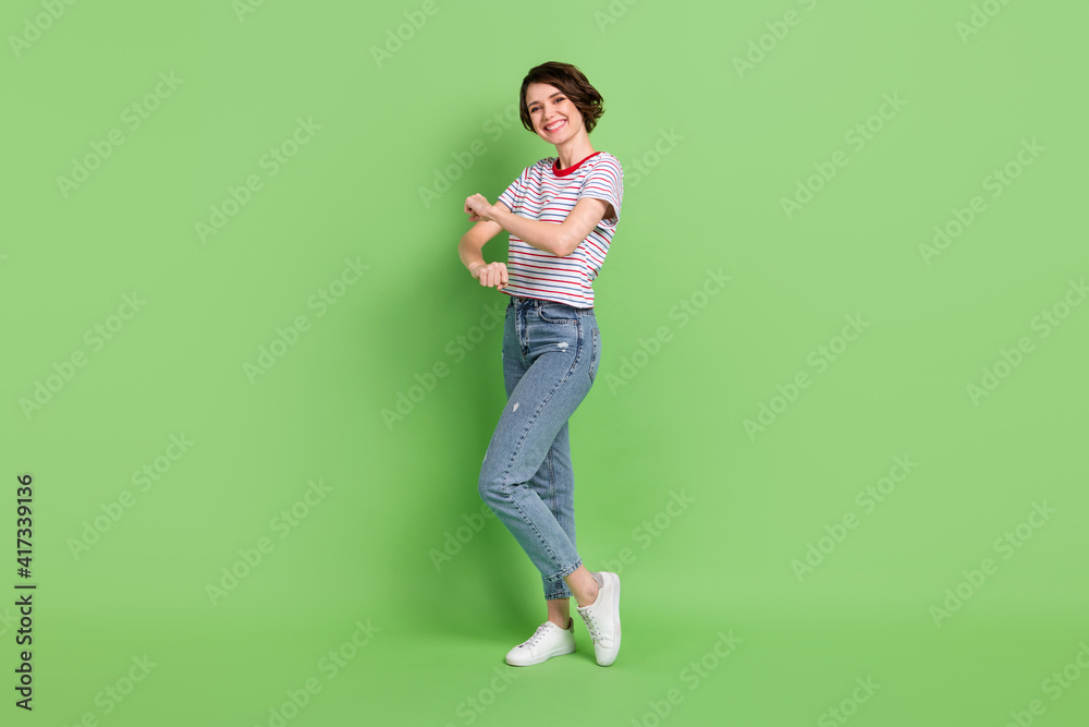 Full length body size view of attractive cheerful childish girl dancing having fun rest isolated over green pastel color background Full length body size view of attractive cheerful childish girl dancing having fun rest isolated over green pastel color background