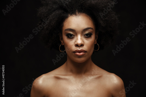 African american shirtless woman posing and looking at camera