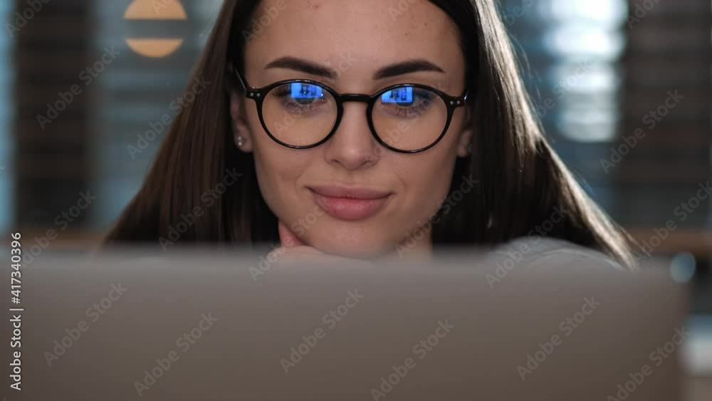 A beautiful woman is talking with video connection using her laptop sitting inside the apartments A beautiful woman is talking with video connection using her laptop sitting inside the apartments