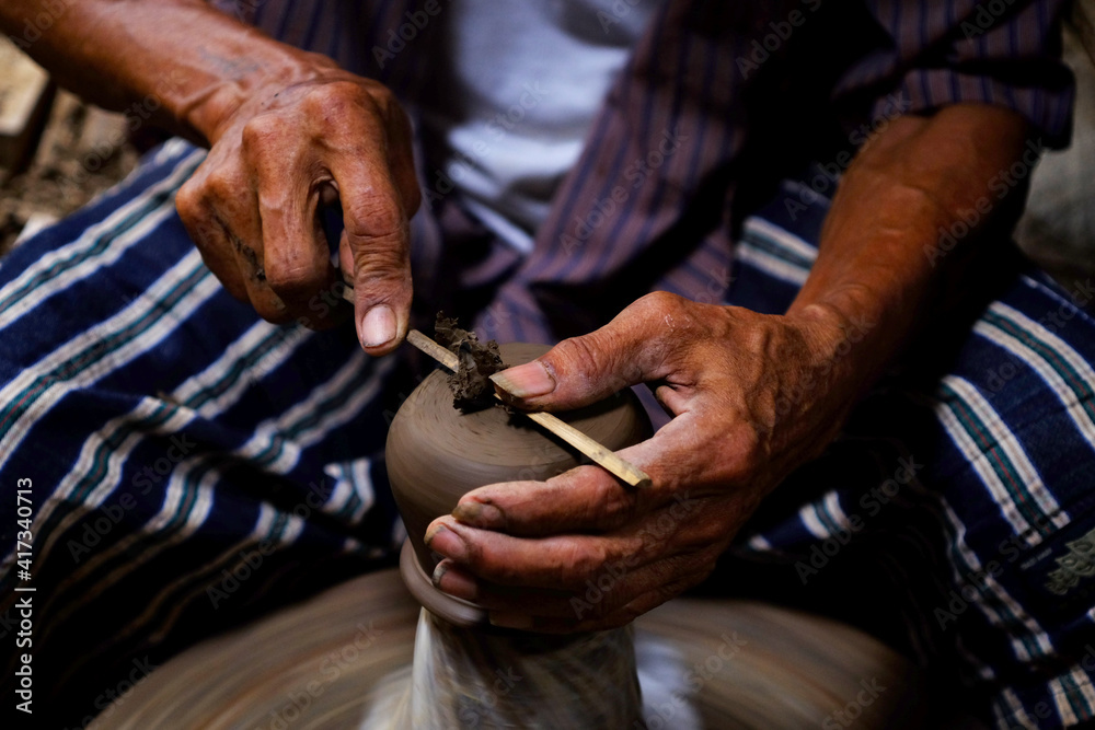 Professional thai old man using mechanic pottery made earthenware at Koh Kret in Nonthaburi Thailand