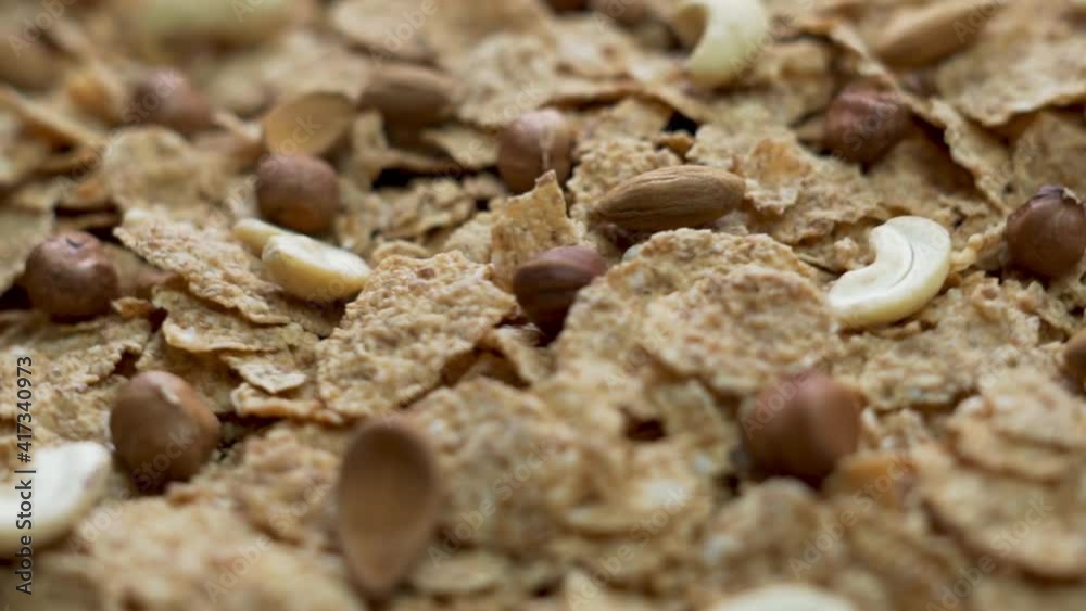 Healthy Flakes with Nuts, Close-up, Rotate. Isolated Background of Fitness Flakes with Nuts. The Concept of Healthy Vegan Food and Vegetarian Food. Healthy Flakes with Nuts, Close-up, Rotate. Isolated Background of Fitness Flakes with Nuts. The Concept of Healthy Vegan Food and Vegetarian Food.