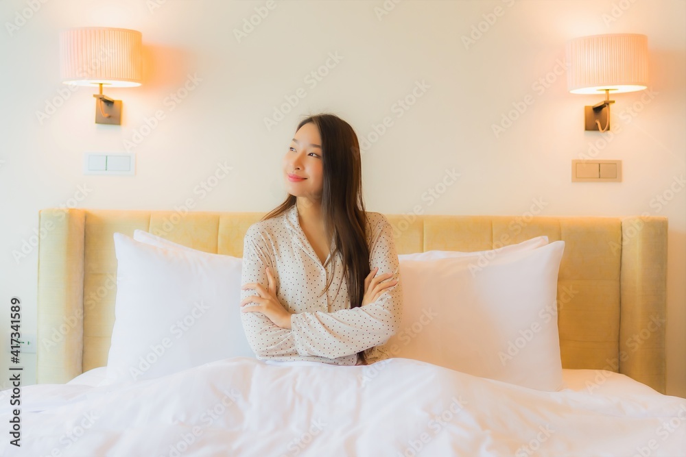 Portrait beautiful young asian woman smile happy relax on bed