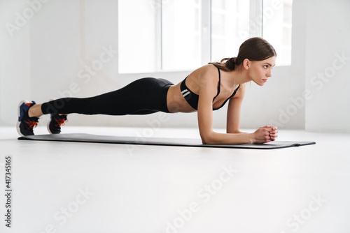 Athletic young sportswoman doing exercise while working out