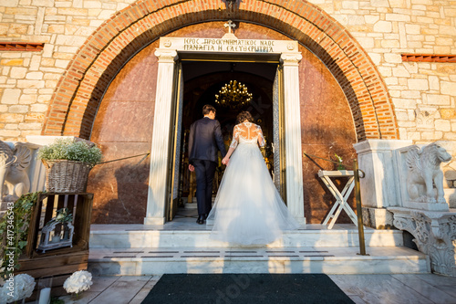 Bride and groom entering in a church in wedding dress