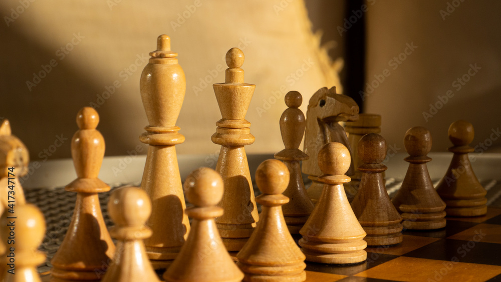 White wooden chess pieces in warm light. White wooden chess pieces in warm light.