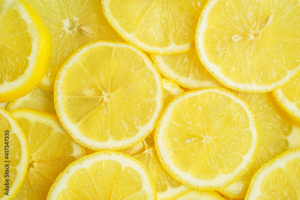 Fruit background, top view. Juicy yellow lemon cut into round slices.