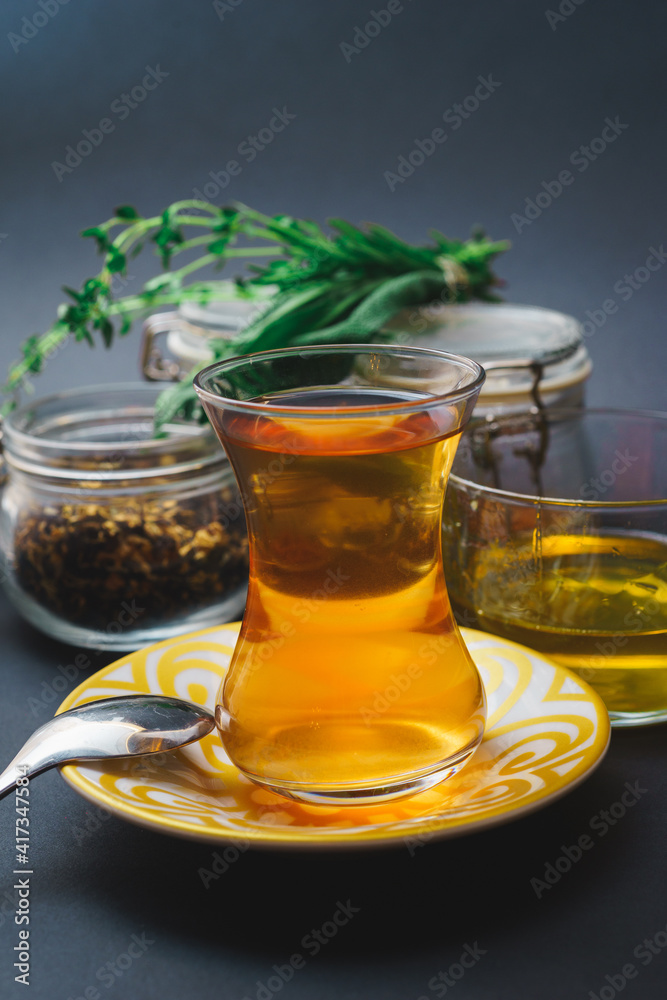 Traditional tea in a glass, tea ceremony with aromatic herbs, mint and honey.