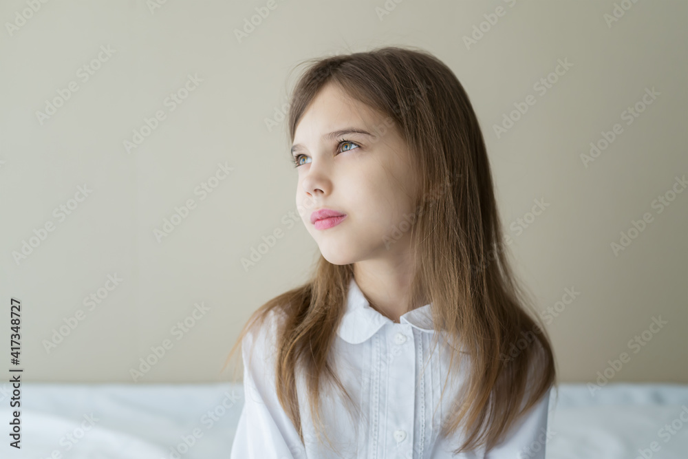 Close up shot of beautiful blonde caucasian little girl in a white shirt, looking calm and dreamy Close up shot of beautiful blonde caucasian little girl in a white shirt, looking calm and dreamy