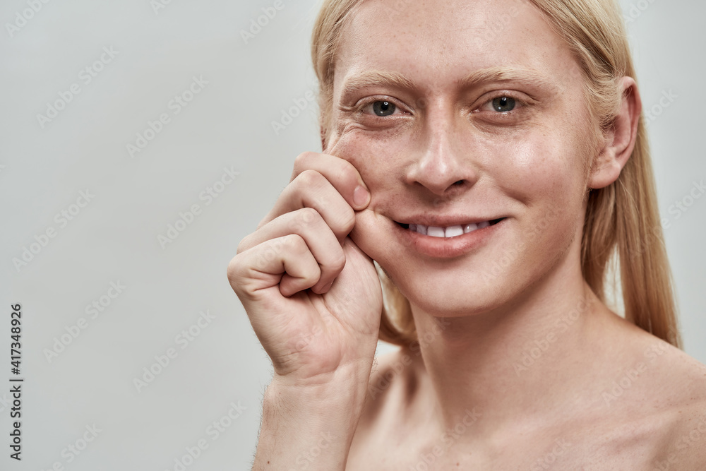 Groomed young caucasian man tightening his cheek Groomed young caucasian man tightening his cheek