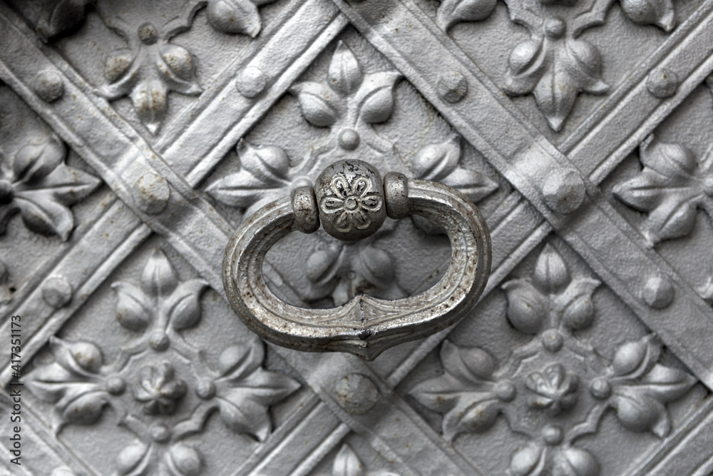 old metal  doorhandle with cast patterns detail