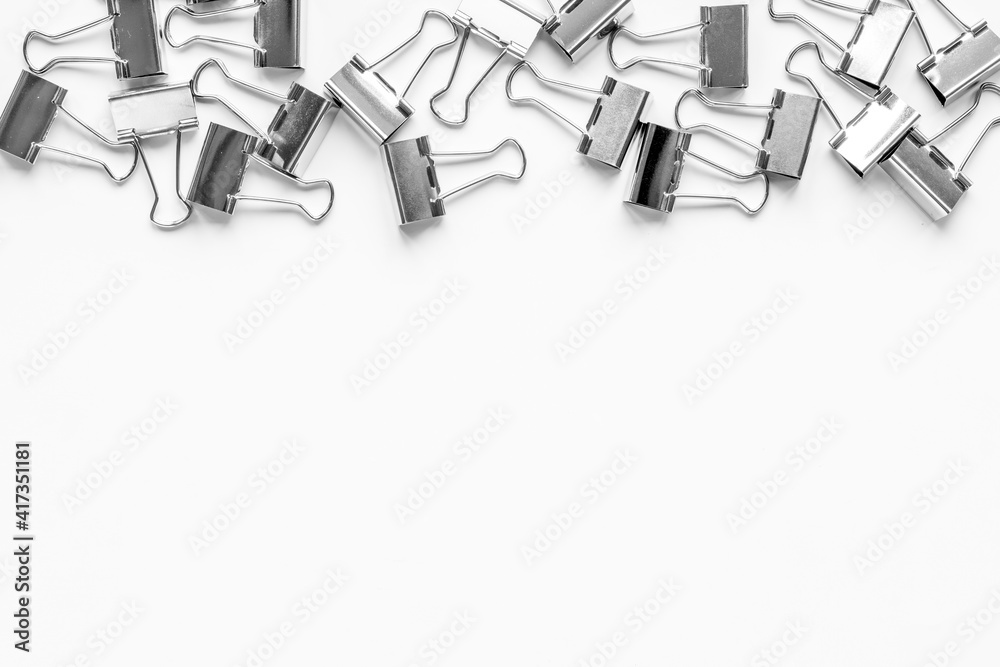 Stationery and office supplies background. Paper binder clips top view