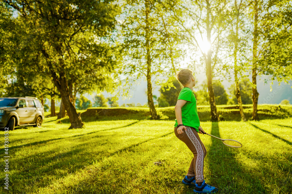 one young boy playing in badminton outdoors one young boy playing in badminton outdoors