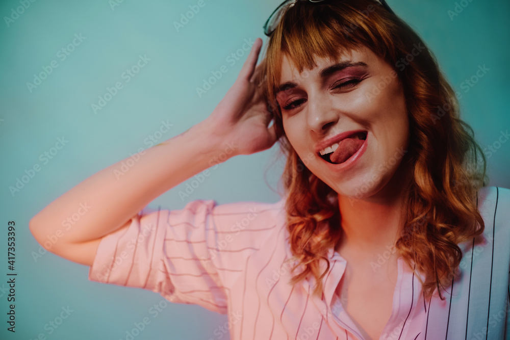 Beautiful girl on a blue background wearing glasses. A student wears glasses in the evening in neon