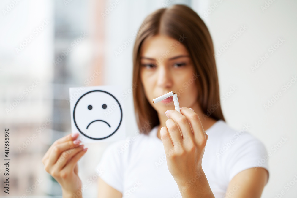 Stop smoking, woman holding a broken cigarette Stop smoking, woman holding a broken cigarette