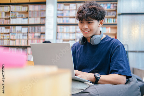 Young collage student using computer and mobile device studying online. photo