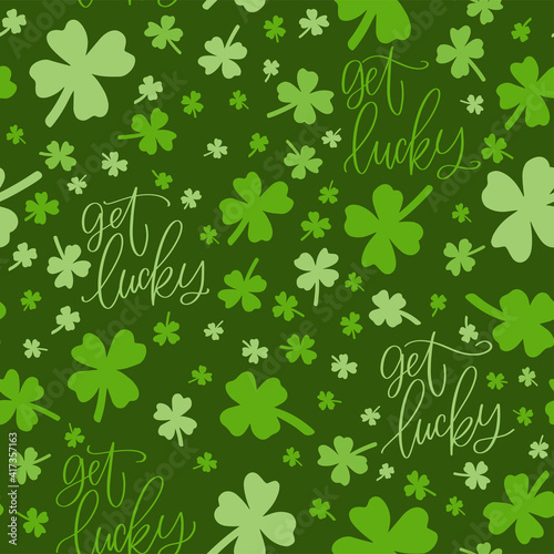 St. Patrick’s day vector seamless pattern with dark green background, shamrock and get lucky calligraphy sign.