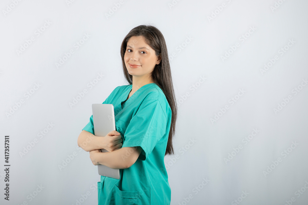 Portrait of young nurse holding laptop on white background Portrait of young nurse holding laptop on white background
