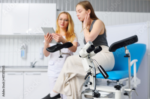 Foto colposcope close-up on the background of a blurry image of a gynecologist and a patient in a blue gynecological chair