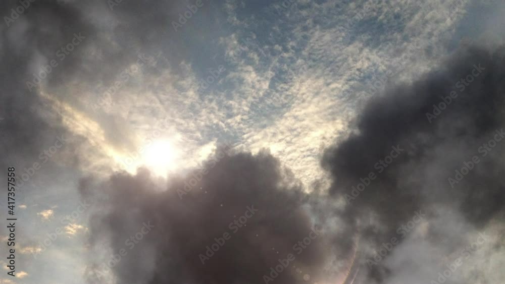 atmosphere, the sun shining among the dark clouds in the blue sky