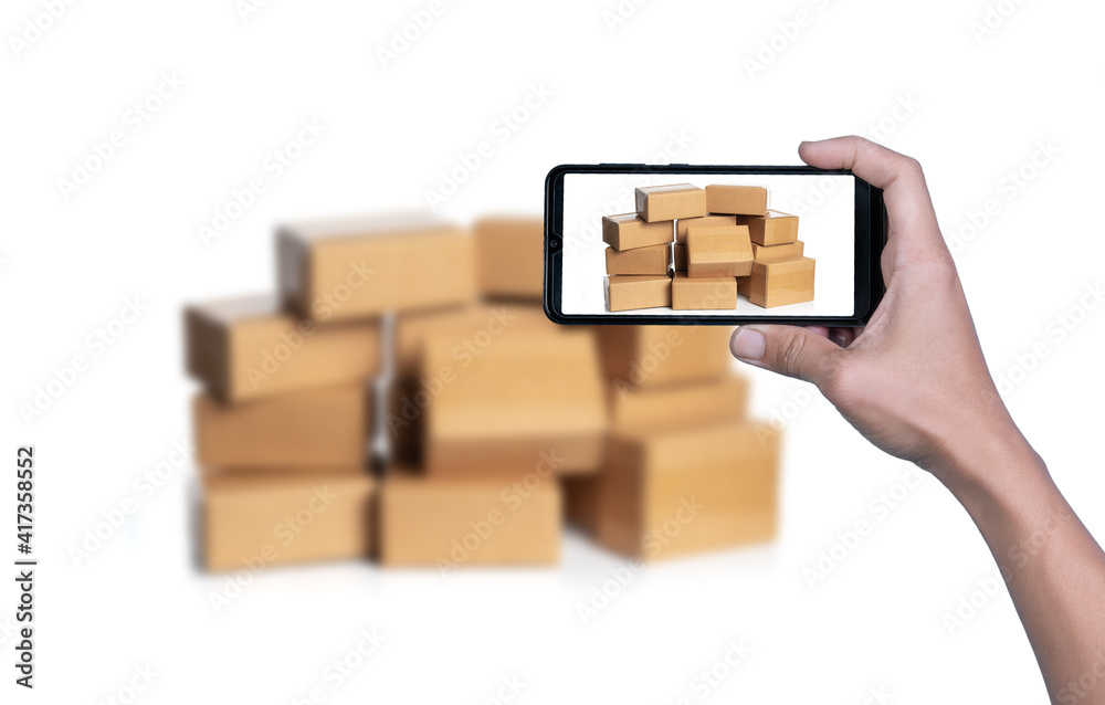Obraz premium Hand taking photo of cardboard boxes for delivery or moving with smart phone