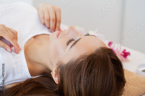 Beautiful young woman relaxing with hand massage at beauty spa salon.