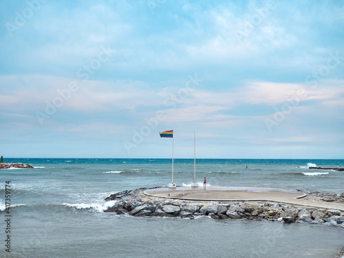 breakwater in marbella with the gay flag waving