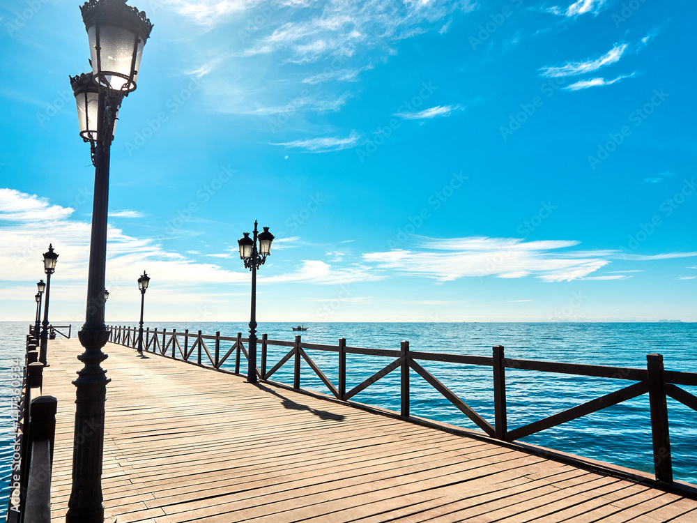 Sandy beach and wooden pier on the Costa del Sol in Marbella, Spain