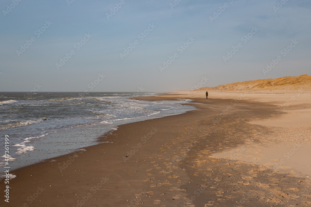 Walking along the North Sea beach and the dunes on the Wadden island of Texel on a beautiful sunny winter day