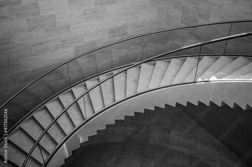 Obraz premium Black and white image of a concrete stairs with metal handlebars