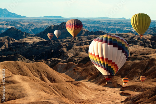 Colorful balloons flying over the moon valley mountain. Africa. Namibia.