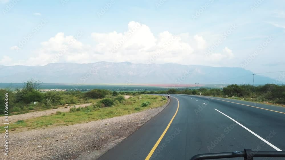 Driving On The Road In Tanzania With Distant View Of Pare Mountains At Daytime. Driver's POV, wide shot Driving On The Road In Tanzania With Distant View Of Pare Mountains At Daytime. Driver's POV, wide shot