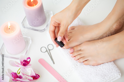 Cheerful Girl Doing Nails Making Pedicure Sitting In Bed Indoor.