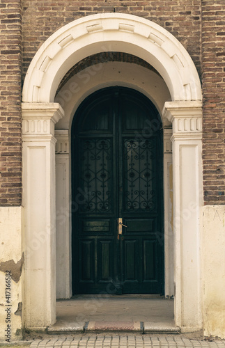 puerta verde en portal con marco blanco