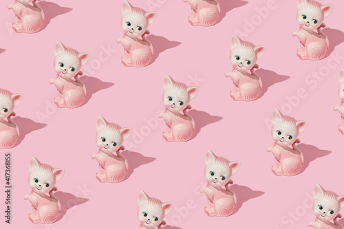 Creative pattern made with cat or kitten vintage figurine on pastel pink background. Retro aesthetic idea. Romantic vintage concept.