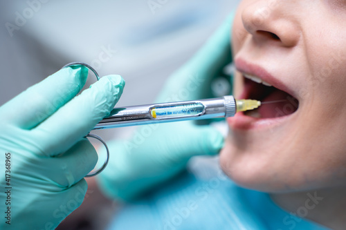 Dentist hand holding syringe with anesthetic before surgery