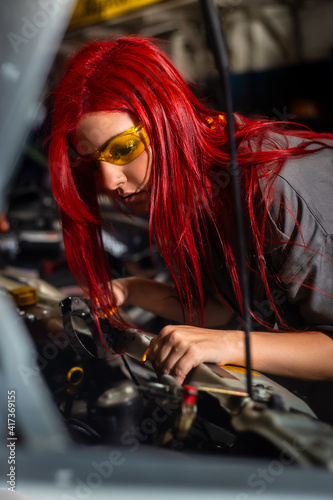 Auto car repair service center. Mechanic standing by the car. Auto mechanic working in garage. Repair service. young woman working in workshop. shot of handsome car mechanic repairing automobile 