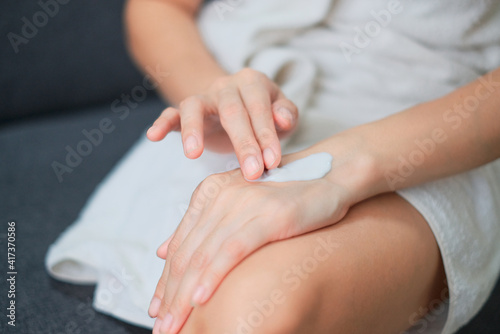 Woman applying natural cream  Woman moisturizing her hand with cosmetic cream  Spa and Manicure concept.