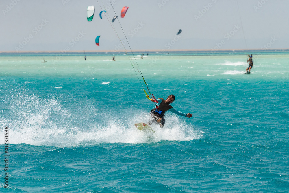 Obraz premium Kitesurfing on the waves of the Red sea, Egipt. Kitesurfing, Kiteboarding action photos Kitesurfer In action