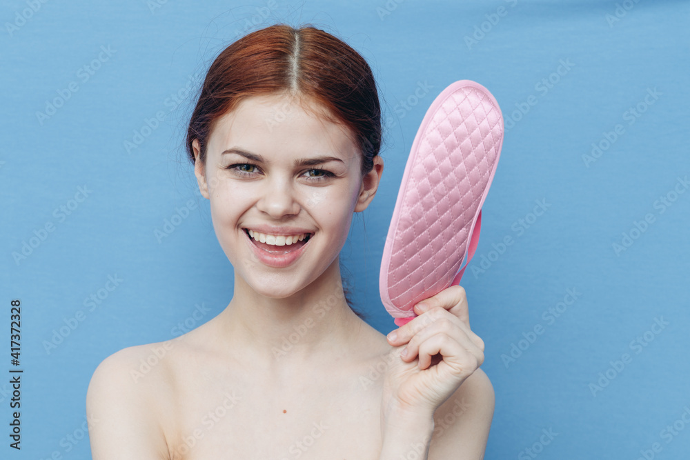 portrait of beautiful woman with pink sleep mask on blue background cropped view portrait of beautiful woman with pink sleep mask on blue background cropped view