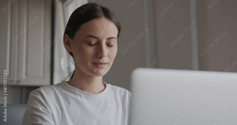 Portrait of charming woman with brown hair working on portable computer while staying at home. Beautiful female in casual wear using modern laptop . Portrait of charming woman with brown hair working on portable computer while staying at home. Beautiful female in casual wear using modern laptop .
