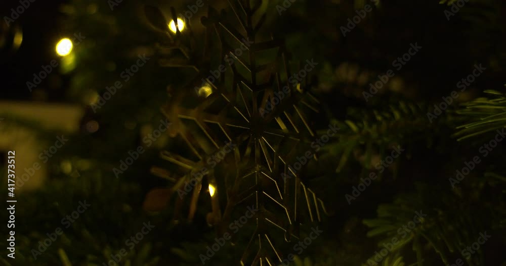 Shiny golden snowflake ornament hanging on the Christmas tree. Closeup Shiny golden snowflake ornament hanging on the Christmas tree. Closeup